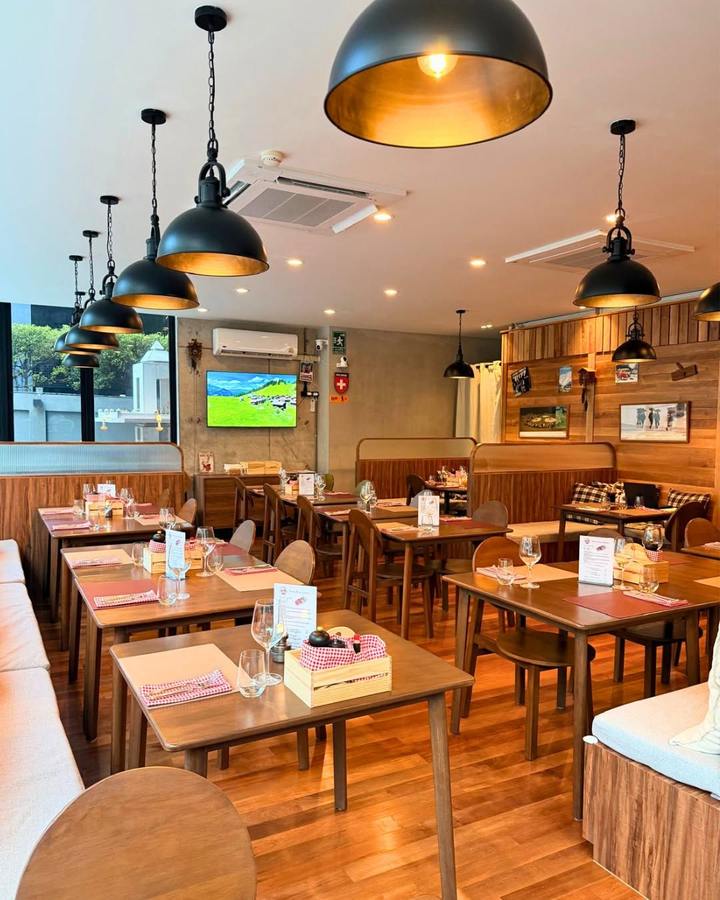 The dining room, wooden tables under black pendant lamps
