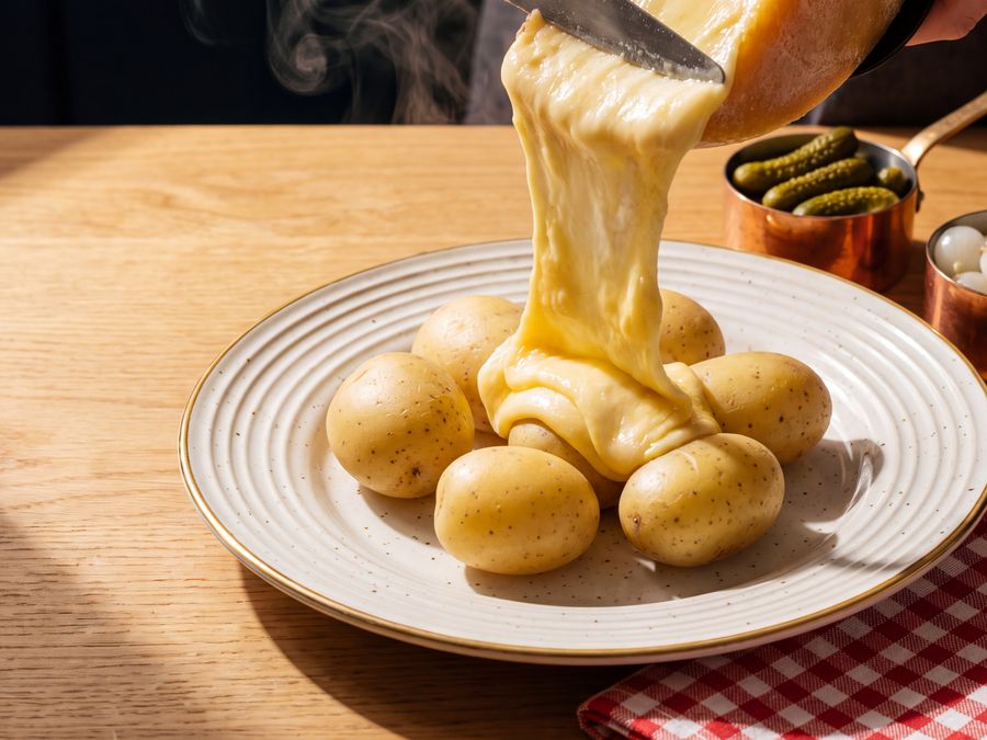 Molten raclette scraped over hot boiled potatoes