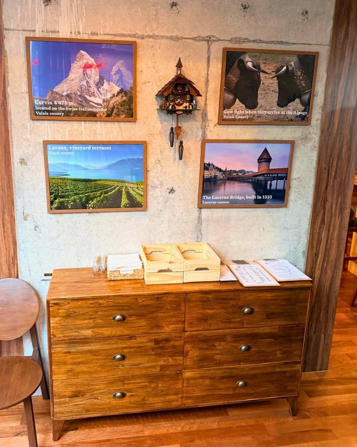 Framed photographs of the Matterhorn, Lavaux and Lucerne beside a cuckoo clock